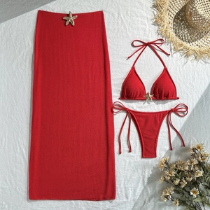 Detailed flat lay of a red textured bikini set with starfish ornaments and mesh skirt