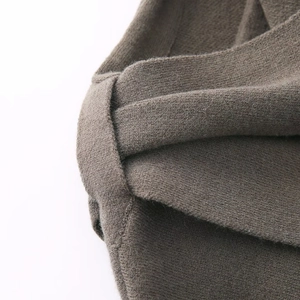 Detail of taupe knitted shawl showing cross-knot texture and wool blend fabric finish