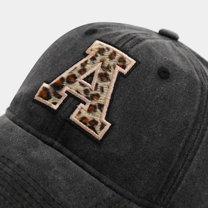 Close-up of charcoal cotton baseball cap with leopard print letter A embroidery detail