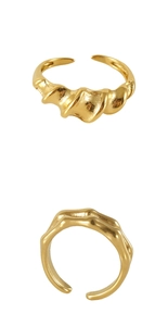 Detail showing the wavy gold texture and adjustable open band of the stainless steel ring