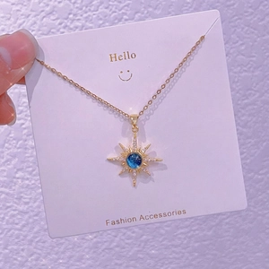Dettaglio della collana a stella con gemma blu scuro e catena a croce dorata