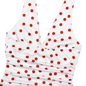 Close-up of white halter dress with red polka dots and ruched deep V-neck details