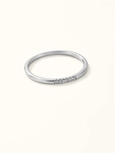 Macro detail of slim silver ring band featuring five sparkling inlaid zircon stones