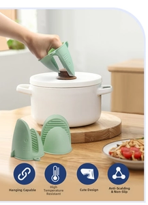 Green shark silicone heat resistant oven mitt showing anti-slip grip on a pot lid