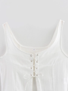 Detail of white tie-front crop top showing ribbed texture and delicate lace-up neckline