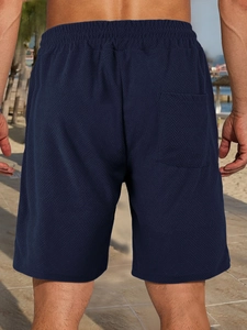 Close-up of textured jacquard fabric and back pocket on dark blue men's casual shorts