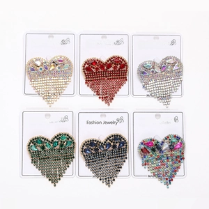 Detail of diverse heart-shaped tassel brooches featuring vibrant rhinestones on cards