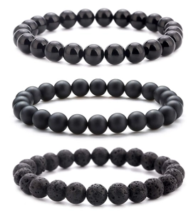 Detail of volcanic lava stone and black obsidian beads showing different matte and glossy textures