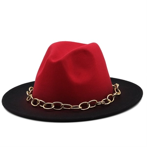 Detail shot of the red and black two-tone fedora with a chunky gold chain accessory