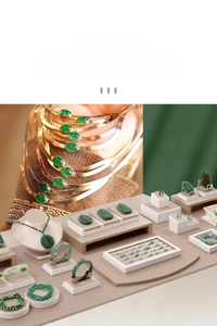 Dettaglio di bracciali, anelli e collane in giada verde su un espositore professionale