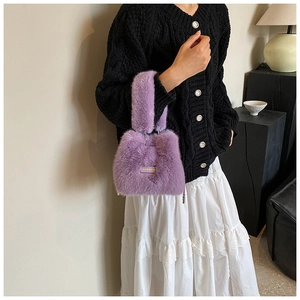 Detail shot of purple plush bucket bag with yellow 'I love every day' tag and metal chain