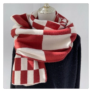 Detail of red and white checkerboard knit scarf draped on a mannequin for winter