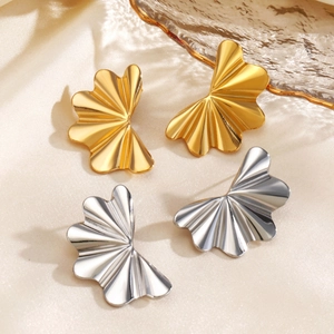 Boucles d'oreilles vagues minimalistes dorées et argentées sur fond de soie élégant