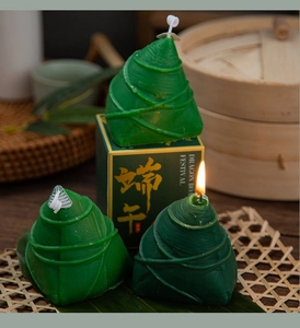 Close-up of zongzi-shaped scented candles on bamboo mat for Dragon Boat Festival