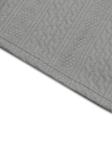 Detailed close-up of grey knitted fabric with geometric texture and neat stitching