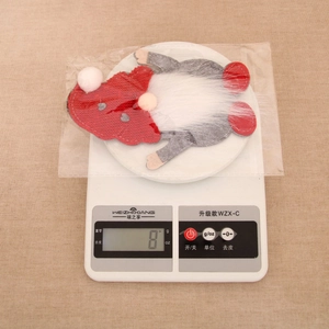 Close-up of a Christmas gnome cutlery holder in red and grey, weighing 8g on a scale