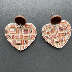 Detailed heart-shaped acrylic earrings featuring a bookshelf print and brown studs