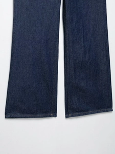 Detalle del dobladillo de mezclilla azul oscuro con costuras en contraste en el pantalón