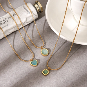 Detailed view of three gold-plated necklaces featuring blue cat-eye stone pendants