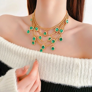 French emerald fringe necklace with gold chains and crystals on model neck