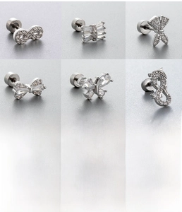 Detailed close-up of six silver surgical steel ear studs with white zircon butterfly designs