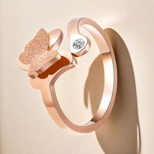 Vue macro d'une bague papillon en or rose avec fini mat et un zircon étincelant