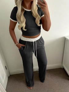 Detail of dark grey ribbed knit set showing white contrast trim and drawstring waist