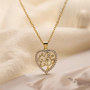 Macro shot of gold heart necklace with tree of life design and zircon inlay