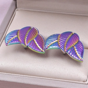 Macro detail of iridescent leaf earrings in a jewelry box with rainbow metal finish