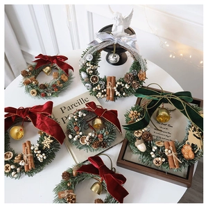 Close-up of Christmas wreath with velvet bows, pine cones, bells and cinnamon sticks