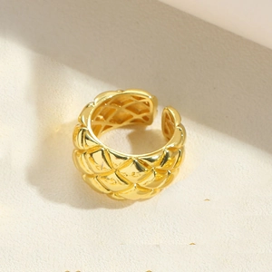 Close-up of golden adjustable ring featuring a textured quilted pattern and S925 stamp