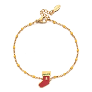 Détail d'un bracelet en acier inoxydable avec billes jaunes et breloque botte de Noël