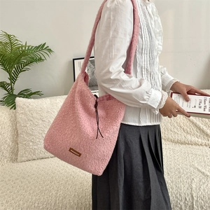 Detalle del bolso tote de felpa rosa con etiqueta de cuero y forro de cuadros