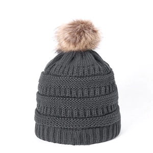 Dark grey knitted winter hat for children featuring a soft brown faux fur pompom decoration