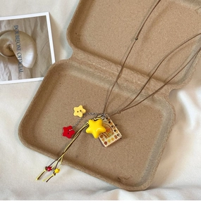 Detail of creative star pendant necklace with yellow star and bear notebook charm