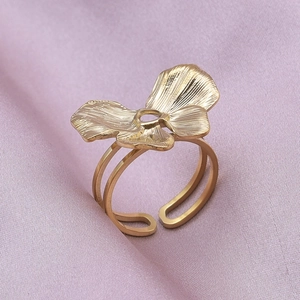 Détail de la bague fleur dorée ajustable avec pétales texturés et design à double anneau