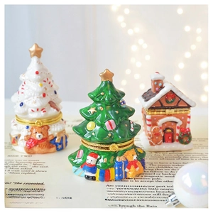 Exquisite ceramic Christmas tree and gingerbread house jewelry boxes on vintage book background