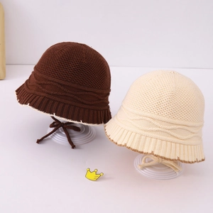 Detail of knitted baby bucket hats with wavy texture and chin straps in brown and beige