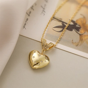 Gros plan du collier avec pendentif cœur doré, motif étoile et pierre en zircon