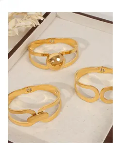 Three-piece gold plated stainless steel open bangle set with geometric knot and ball detail