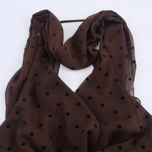 Robe légère en mousseline marron à pois noirs sur fond blanc épuré et moderne