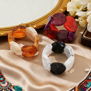Detailed close-up of retro acrylic resin stretch bracelets with marble texture on silk