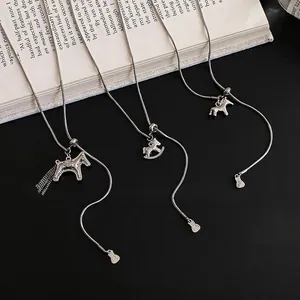 Three minimalist silver horse necklaces with tassel and rocking horse charms on snake chains
