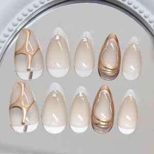 Short almond press-on nails with white French tips and golden 3D metallic relief lines