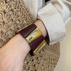 Detail of vintage acrylic bracelet with gold metal blocks and burgundy resin textures