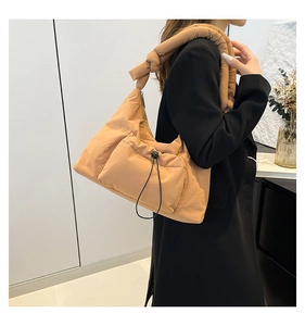 Detail of caramel nylon cloud hobo bag with knotted strap and drawstring pocket