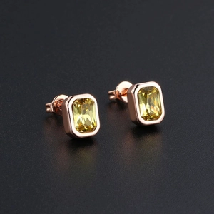 Macro shot of rectangular emerald-cut lime green zircon earrings in rose gold setting