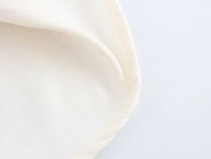 Gros plan sur la texture du tissu blanc et les coutures de la robe à volants étagés