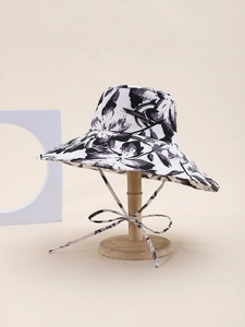 Detailed view of the large brim sun hat featuring floral prints and adjustable chin strap