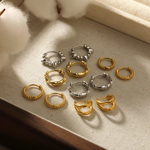 18k gold plated Mobius hoop earrings in assorted textures on a beige jewelry display tray